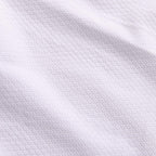 Detaljbild av materialet i vit Budo-Nord Mirai WKF karatedräkt